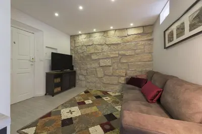a living room with a couch and a stone wall at Santo Ildefonso RicaHouses in Porto