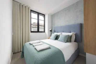 a bedroom with a large bed with a blue headboard at Santo Ildefonso RicaHouses in Porto