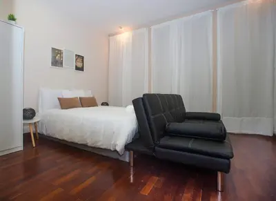 a bedroom with a bed and a black chair at Bonsai Apartment 5 in Porto