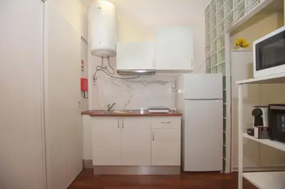 a white kitchen with a sink and a refrigerator at Bonsai Apartment 5 in Porto