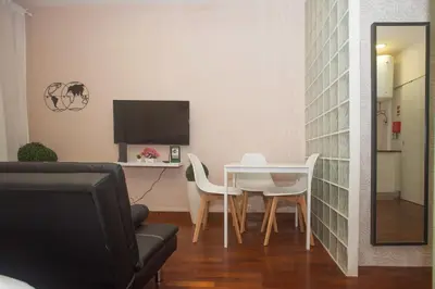 a living room with a table and chairs and a television at Bonsai Apartment 5 in Porto