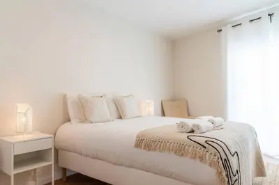 a white bedroom with a bed with towels on it at Morro Garden Apartment by Hosty in Vila Nova de Gaia