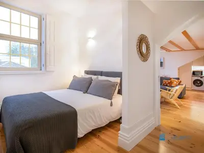 a bedroom with a bed and a living room at Porto Cedofeita Art & Design Loft in Porto