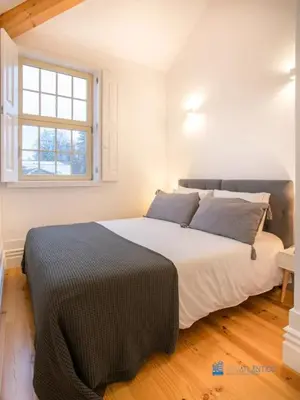 a bedroom with a large white bed with a window at Porto Cedofeita Art & Design Loft in Porto