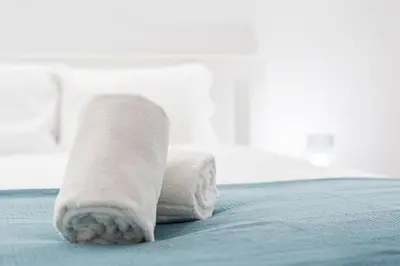 a rolled up towel on top of a bed at Porto Paraíso Right by RDC in Porto