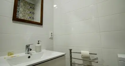 a white bathroom with a sink and a mirror at Casa do Recanto - Studio in Porto