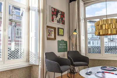 a room with two chairs and a table and windows at Mouzinho Penthouse by Hosty in Porto