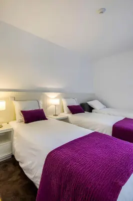 two beds in a room with purple blankets at PATH Bonjardim Apartments in Porto
