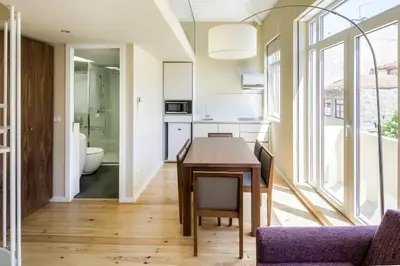 a kitchen and dining room with a table and a bathroom at PATH Bonjardim Apartments in Porto