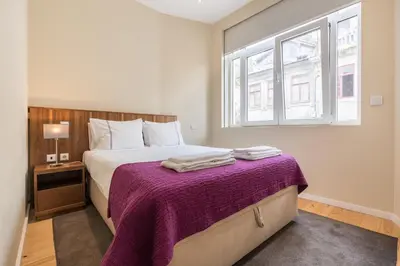 a bedroom with a bed with a purple blanket at PATH Bonjardim Apartments in Porto