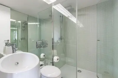 a bathroom with a toilet and a glass shower at PATH Bonjardim Apartments in Porto