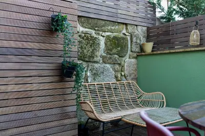 a bench sitting next to a stone wall at Exotic Flat with Shared Pool & Garden in Porto