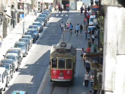 a tram on a city street with parked cars at Citybreak-apartments Sao Bento in Porto