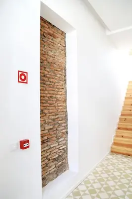 a brick wall in a room with a staircase at Citybreak-apartments Sao Bento in Porto