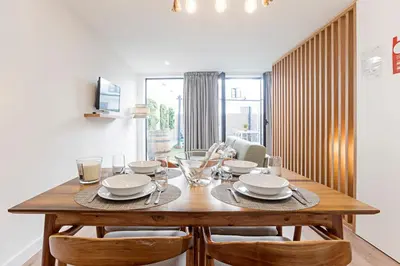 a dining room with a wooden table and chairs at Villa Terra The Garden in Vila Nova de Gaia