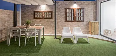 a dining room with a table and white chairs at Villa Terra The Garden in Vila Nova de Gaia
