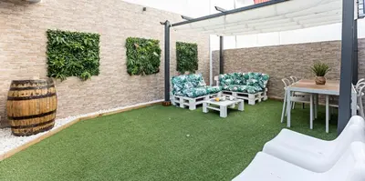 a patio with green grass and a table and chairs at Villa Terra The Garden in Vila Nova de Gaia