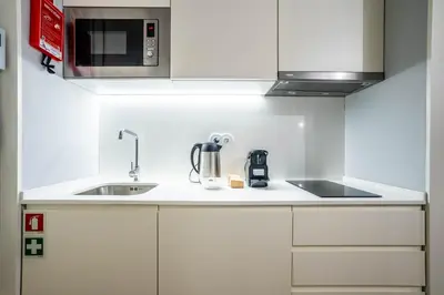 a white kitchen with a sink and a microwave at Sta Catarina 632 by LovelyStay in Porto