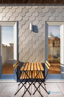 a wooden picnic table sitting in front of a building at Boavista Charm Balcony Loft in Porto