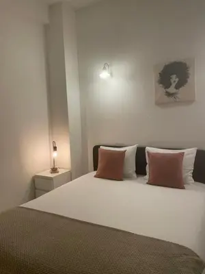 a bedroom with a white bed with two pink pillows at Miguel Bombarda Cozy Apartment in Porto