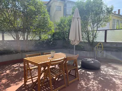 a wooden table and chairs and an umbrella at Miguel Bombarda Cozy Apartment in Porto