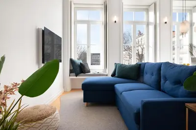 a blue couch in a living room with windows at Quadra Apartment - Luxury & Relaxation in Porto