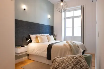 a bedroom with a large bed and a window at Quadra Apartment - Luxury & Relaxation in Porto