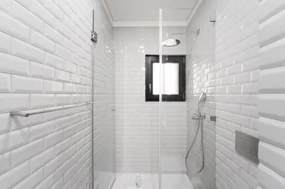 a white bathroom with a shower with a glass door at GuestReady - Lovely heaven in Porto in Porto