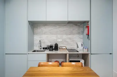 a kitchen with white cabinets and a table and chairs at GuestReady - Lovely heaven in Porto in Porto