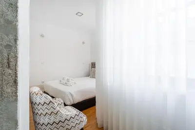 a bedroom with a bed and a chair in a room at GuestReady - Lovely heaven in Porto in Porto