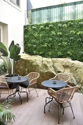 a patio with two tables and chairs and a stone wall at Apartment with balcony in the center of Porto in Porto