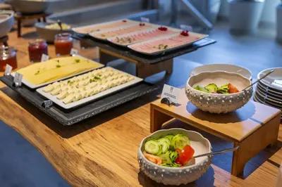a woman with blue nail polish holding a black object over a plate of food at Holiday Inn Express Porto - Boavista by IHG in Porto