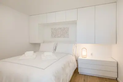 a white bedroom with a white bed and white cabinets at Clérigos Apartments Porto - Premium in Porto
