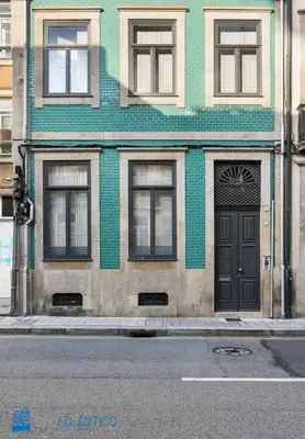 a green building with a door on a city street at Quinta da Boa Vista Garden & Terrace in Porto
