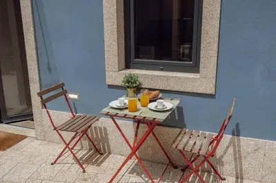 a table with two chairs and two drinks on it at Lapa Cozy by Hosty in Porto