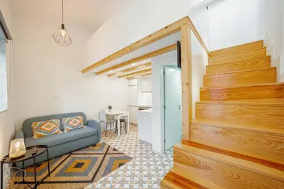 a living room with a blue couch and a staircase at Lapa Cozy by Hosty in Porto