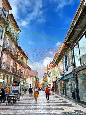 a group of people walking down a city street at Fly me to the Moon in Porto