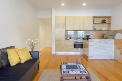 a living room with a couch and a kitchen at Fly me to the Moon in Porto