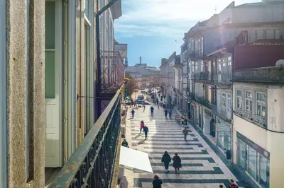 a group of people walking down a city street at Fly me to the Moon in Porto