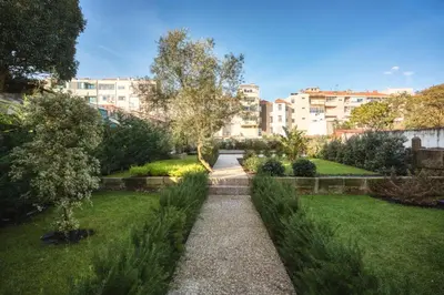 a garden in a city with buildings in the background at Cosy House Downtown Porto with swimming pool and AC in Porto