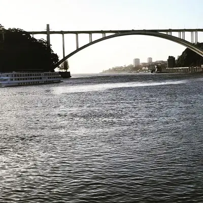 a bridge over a river with a boat under it at River Place in Porto