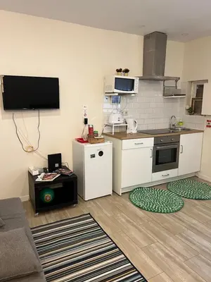 a living room with a kitchen with white appliances at River Place in Porto