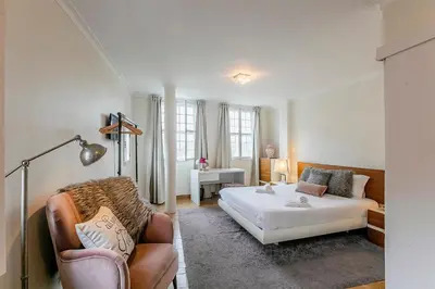 a bedroom with a bed and a couch and a chair at Stunning Clerigos Duplex apartment in the heart of Porto in Porto