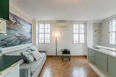 a living room with a couch and some windows at Stunning Clerigos Duplex apartment in the heart of Porto in Porto