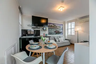 a kitchen and living room with a table and chairs at Stunning Clerigos Duplex apartment in the heart of Porto in Porto