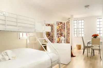 a bedroom with a bunk bed and a table at Clerigos Studio Apts in Porto