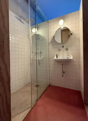 a bathroom with a glass shower and a sink at Casa Astória - City Centre Historical Building with Amazing River View in Porto
