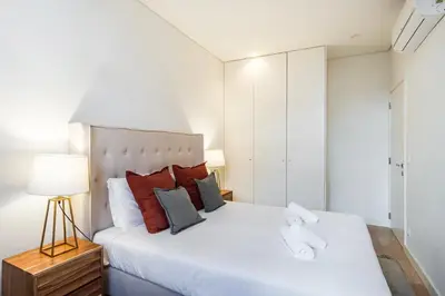 a bedroom with a large white bed with red pillows at GuestReady - A secret passage in Porto in Porto