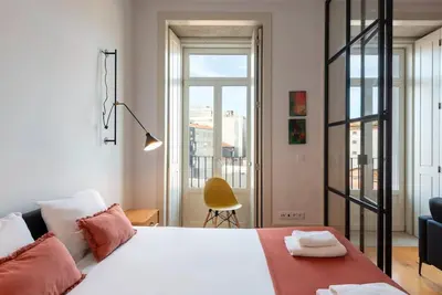 a bedroom with a white bed with two pillows at São Bento Bright Studio in Porto