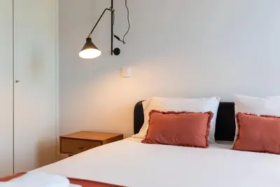 a bedroom with a large bed and a table at São Bento Bright Studio in Porto